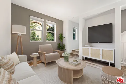 a living room with furniture a flat screen tv and a window