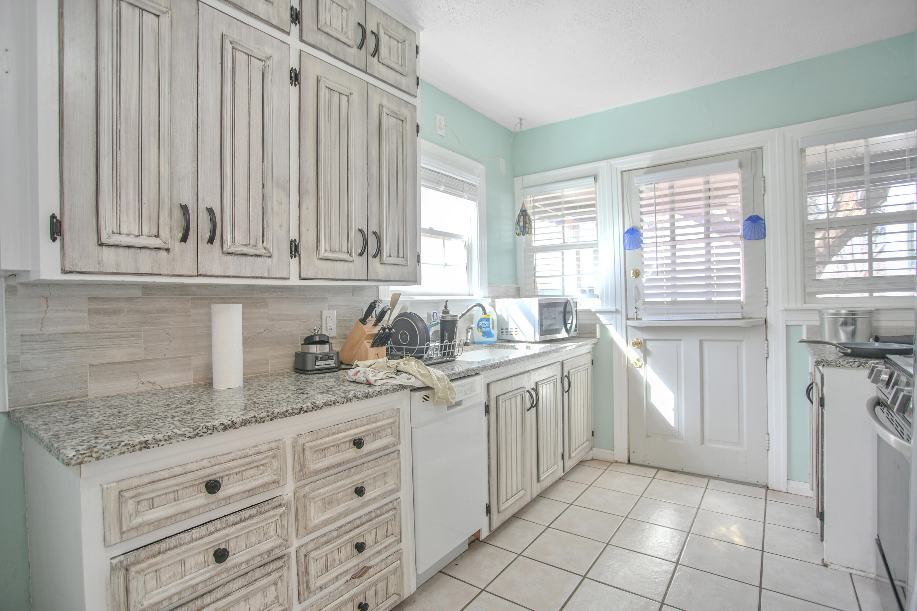 3013 28th Street Lubbock, TX 79410 - Photo 14 of 38 a kitchen with granite countertop white cabinets and white appliances