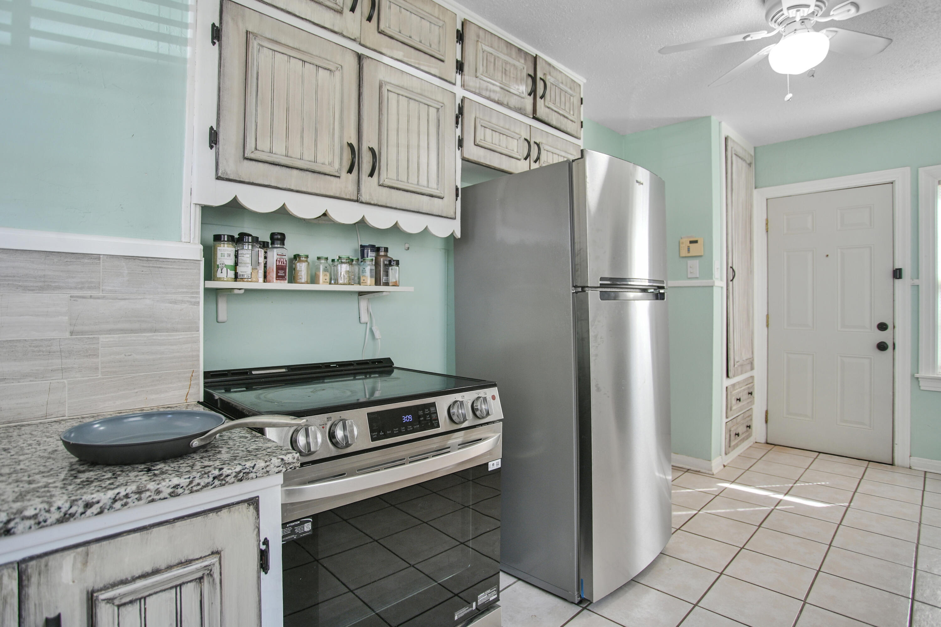 3013 28th Street Lubbock, TX 79410 - Photo 17 of 38 a kitchen with stainless steel appliances granite countertop a refrigerator a stove and a sink