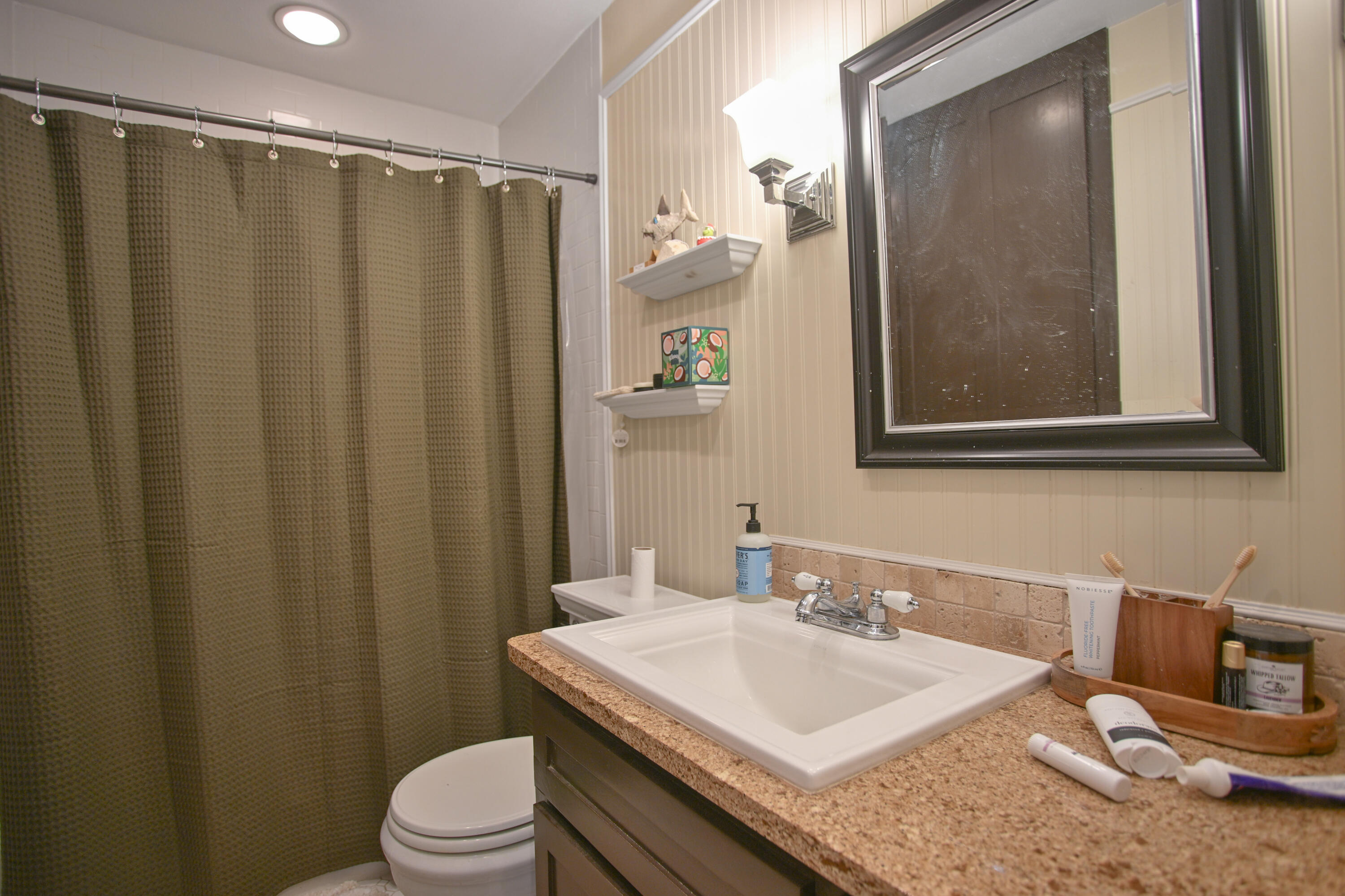 3013 28th Street Lubbock, TX 79410 - Photo 19 of 38 a bathroom with a granite countertop sink toilet and shower
