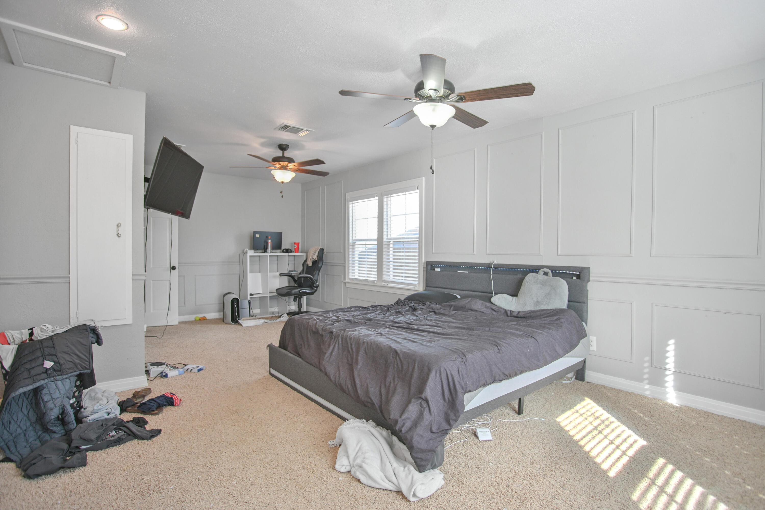 3013 28th Street Lubbock, TX 79410 - Photo 22 of 38 a spacious bedroom with a bed and ceiling fan