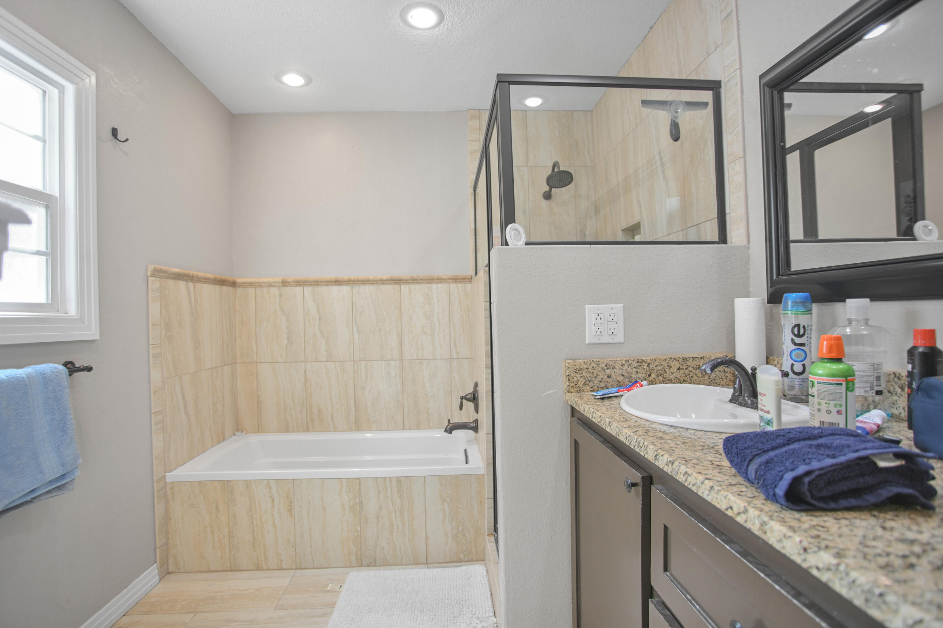 3013 28th Street Lubbock, TX 79410 - Photo 25 of 38 a bathroom with a granite countertop tub sink and mirror
