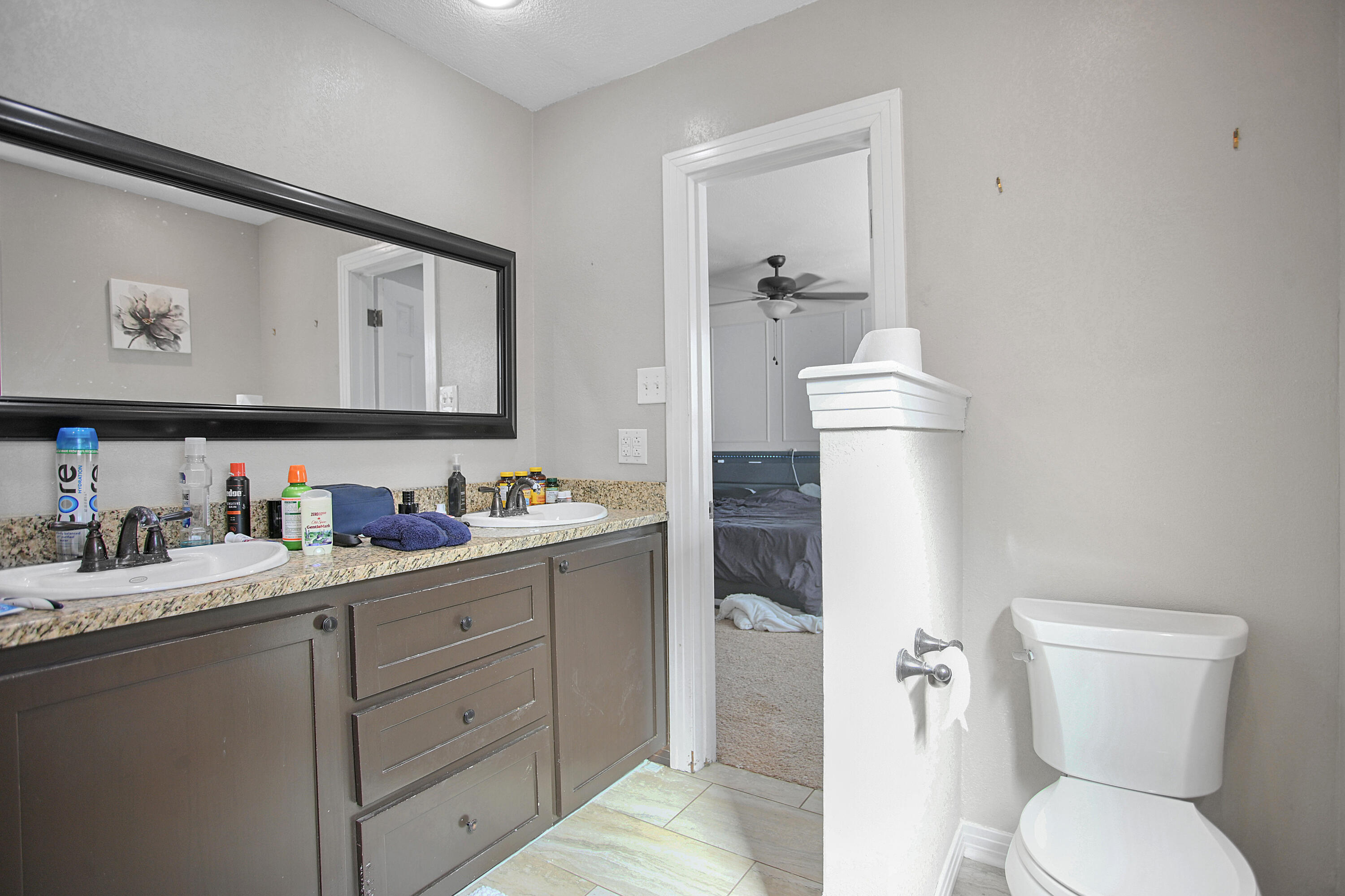 3013 28th Street Lubbock, TX 79410 - Photo 27 of 38 a bathroom with a toilet sink and mirror