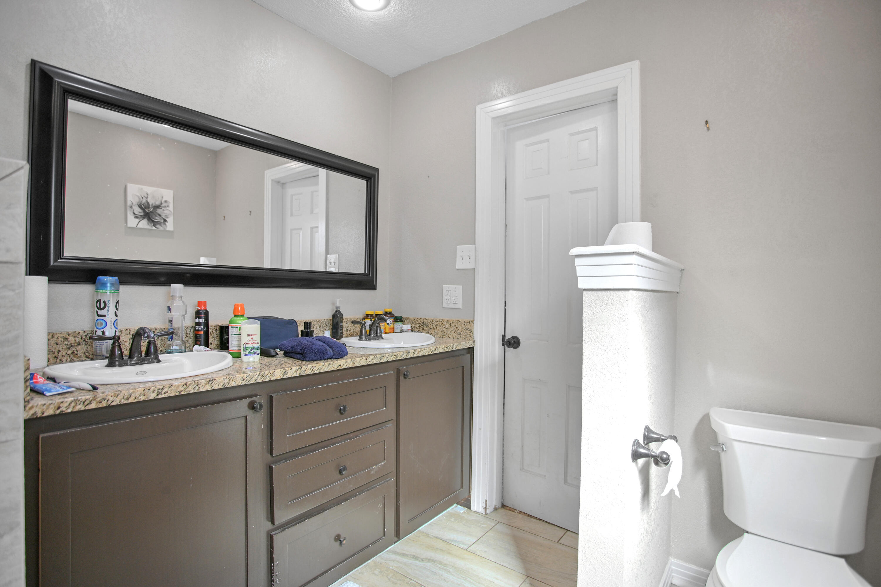 3013 28th Street Lubbock, TX 79410 - Photo 28 of 38 a bathroom with a toilet sink and mirror