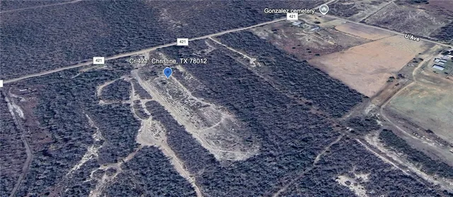 a view of a dry yard with wooden fence