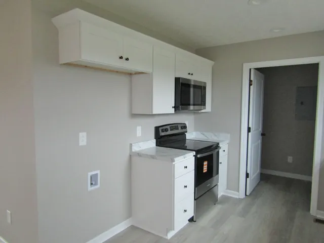 a kitchen with stainless steel appliances granite countertop a stove a sink and a white refrigerator
