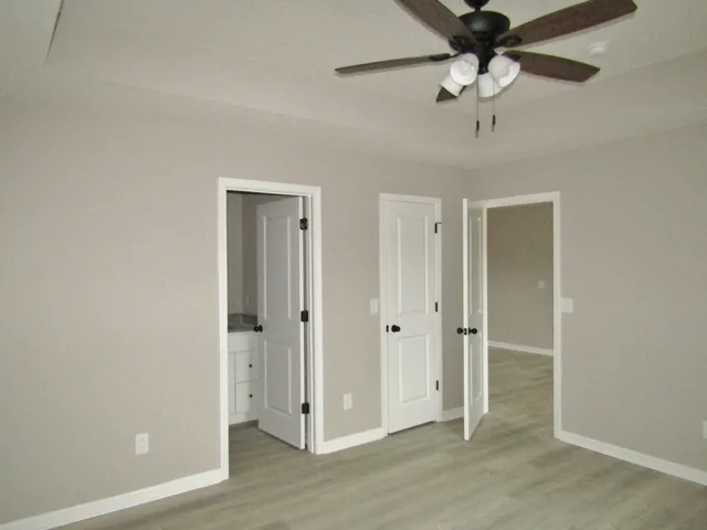 a view of a hallway with a chandelier fan and wooden floor
