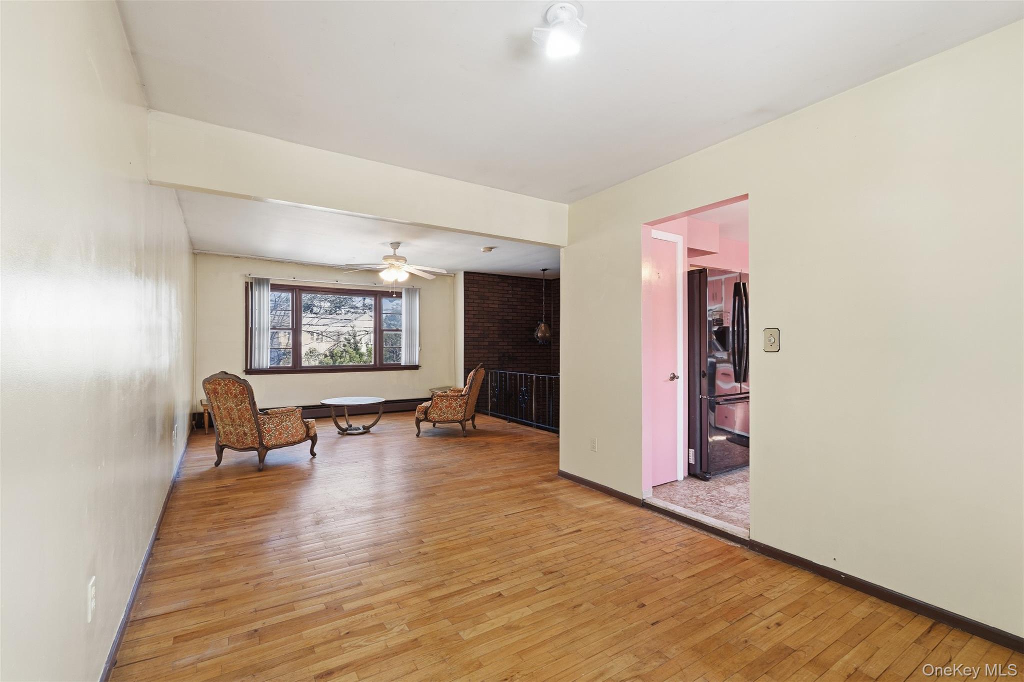 563 Union Road Spring Valley, NY 10977 - Photo 3 of 16 Spacious room featuring wood-finish flooring, a ceiling fan, and a large window with exterior views