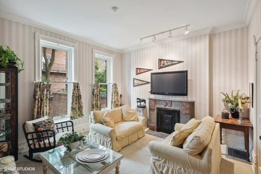 59 East Elm Street Chicago, IL 60611 - Photo 17 of 27 a living room with furniture a flat screen tv and a fireplace
