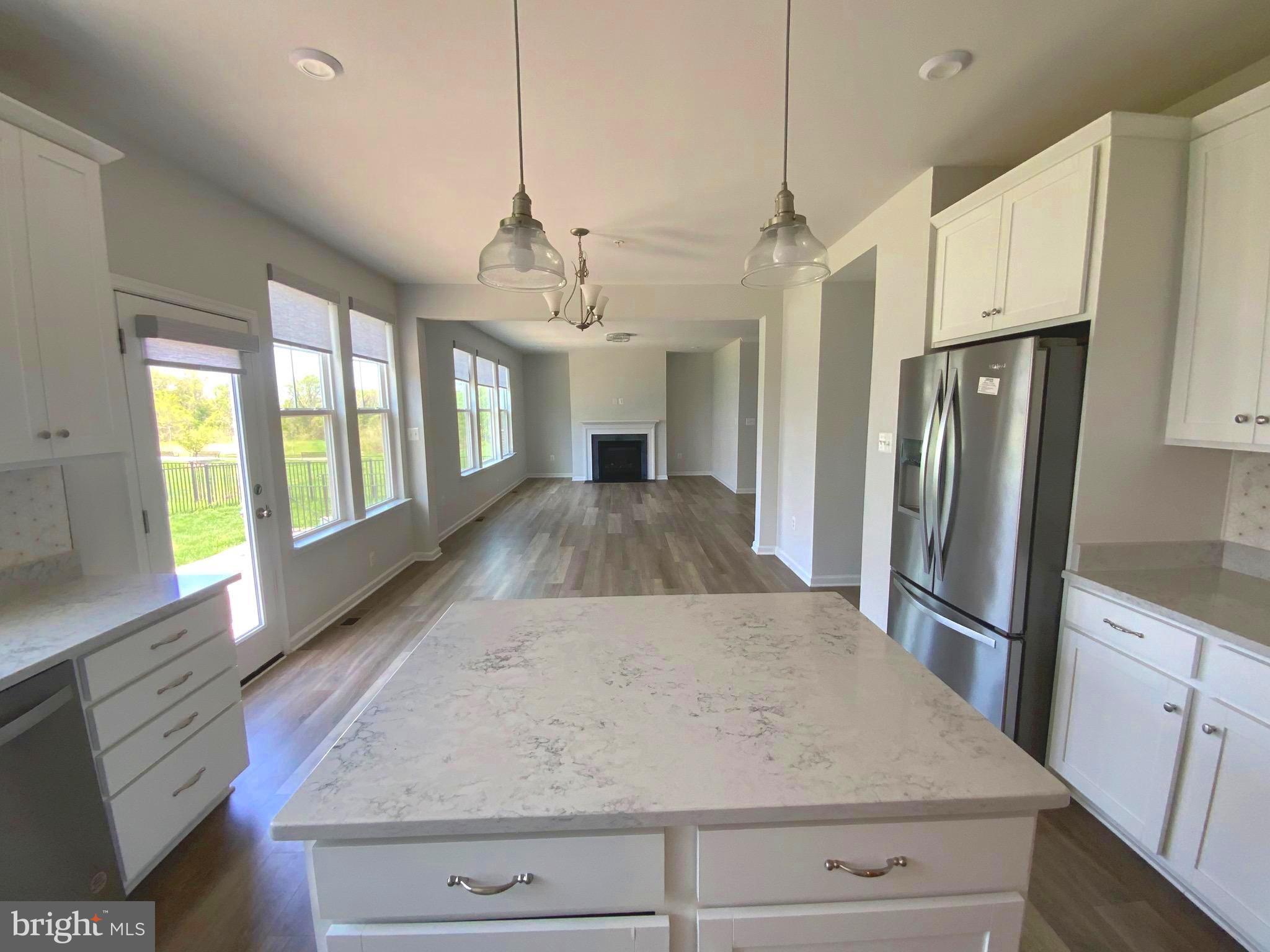 5763 Hawk Ridge Road Frederick, MD 21704 - Photo 14 of 73 a kitchen with stainless steel appliances granite countertop a refrigerator a stove and a sink with wooden floor