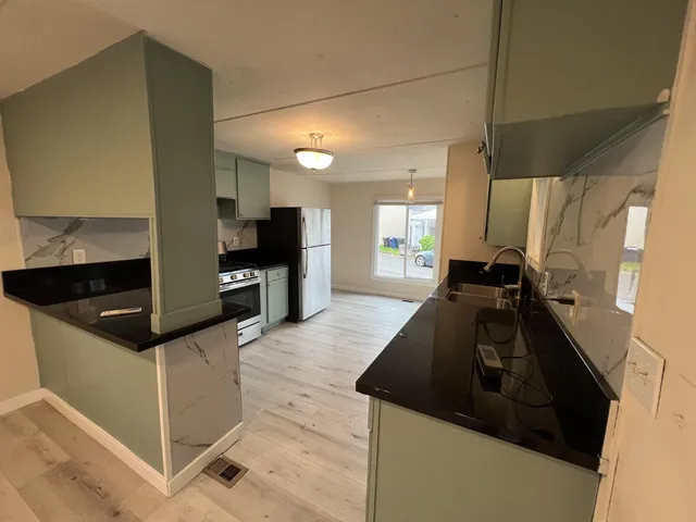 a kitchen with granite countertop a stove and a sink