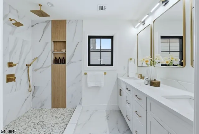 a spacious bathroom with double vanity a mirror and a shower