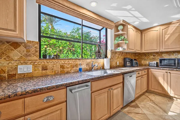a kitchen with granite countertop stainless steel appliances a sink and cabinets