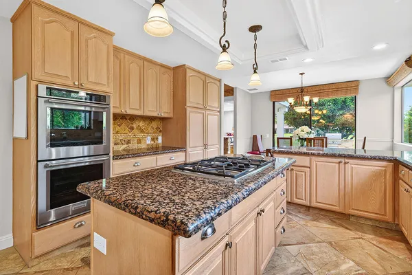 a kitchen with stainless steel appliances granite countertop a stove a sink and a microwave