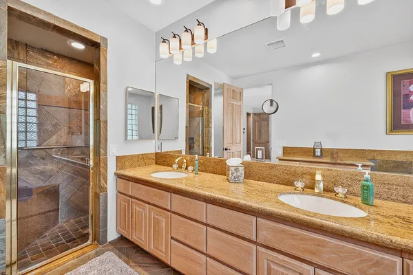 a bathroom with double vanity sinks and a shower