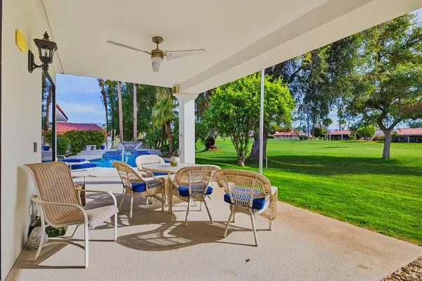a view of a patio with a table chairs and a yard