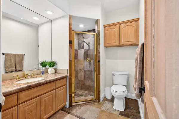 a spacious bathroom with a granite countertop sink toilet and shower