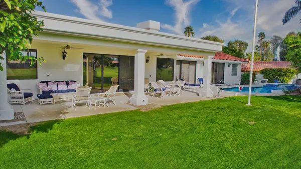 a view of a house with backyard porch and sitting area