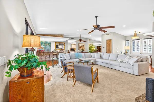 a living room with furniture a chandelier and a potted plant