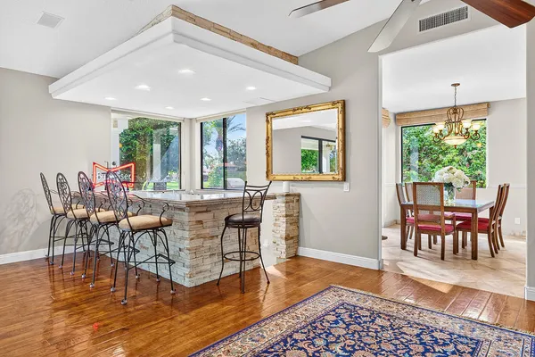 a view of a dining room with furniture a chandelier and wooden floor