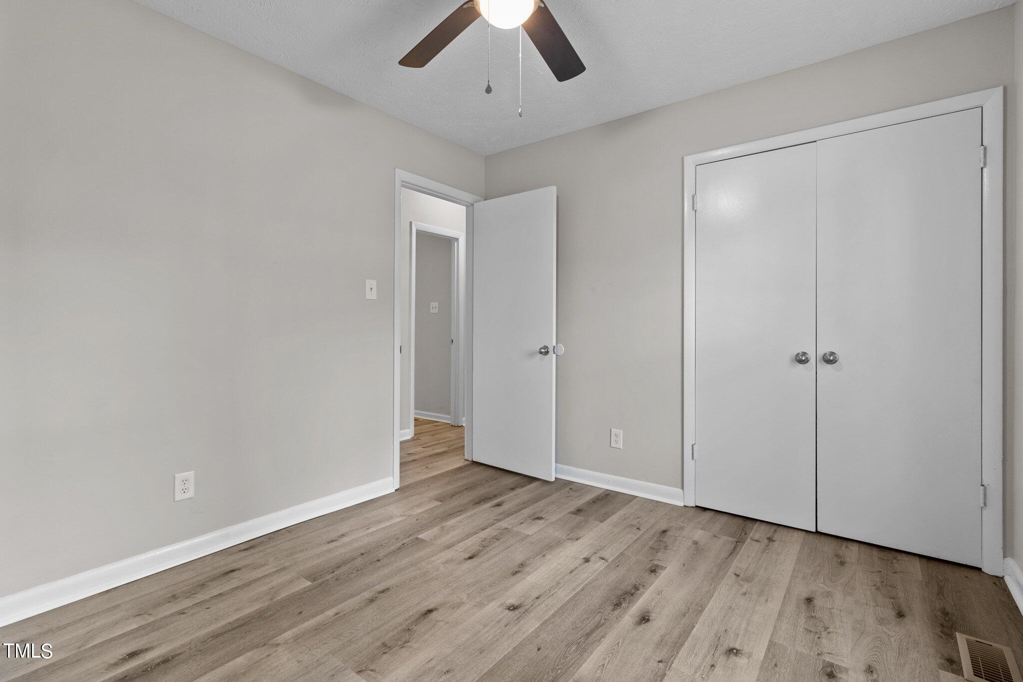 1775 Rim Road Fayetteville, NC 28314 - Photo 13 of 16 an empty room with wooden floor closet and windows