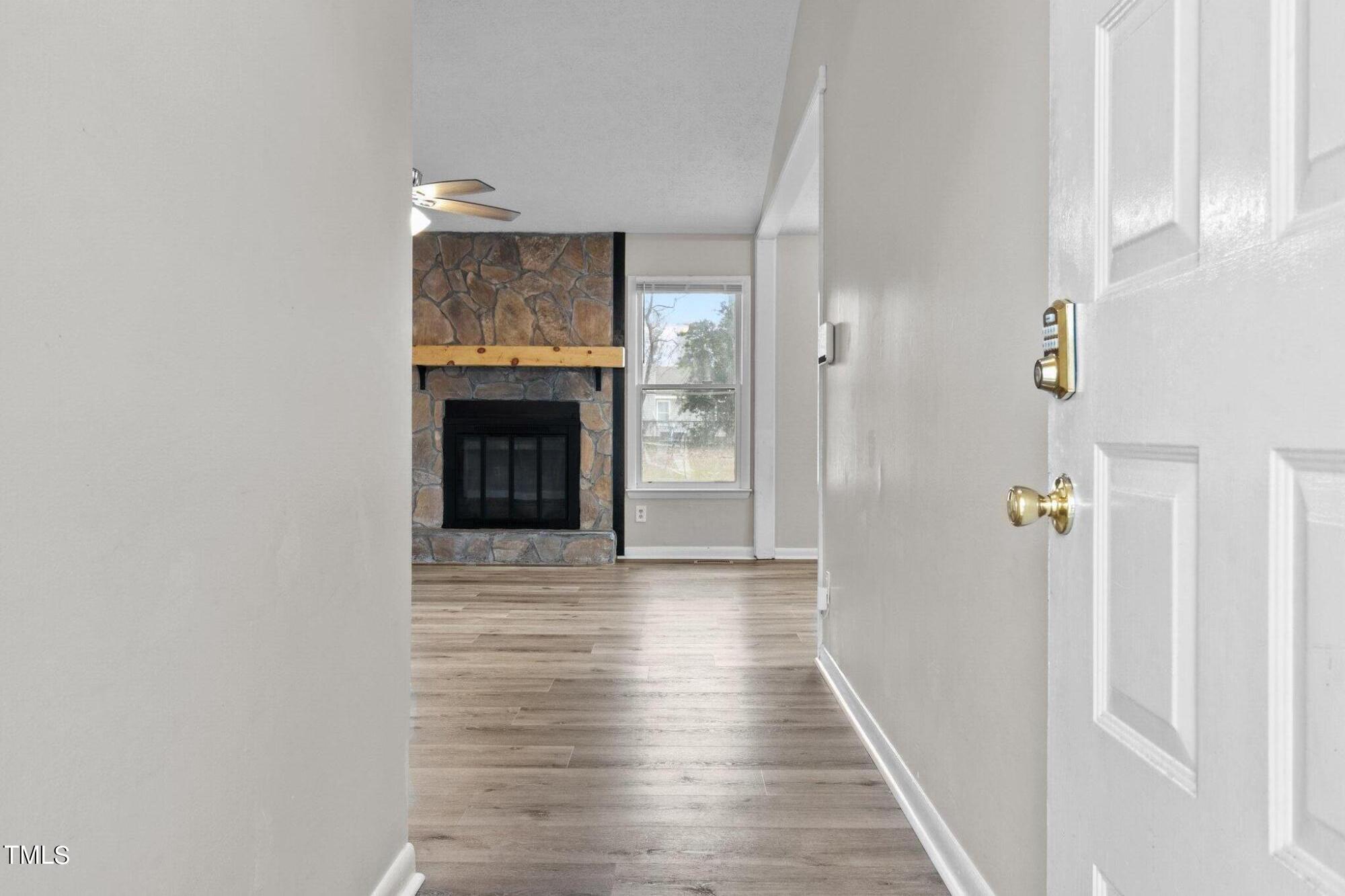 1775 Rim Road Fayetteville, NC 28314 - Photo 2 of 16 a view of a hallway with wooden floor and a fireplace