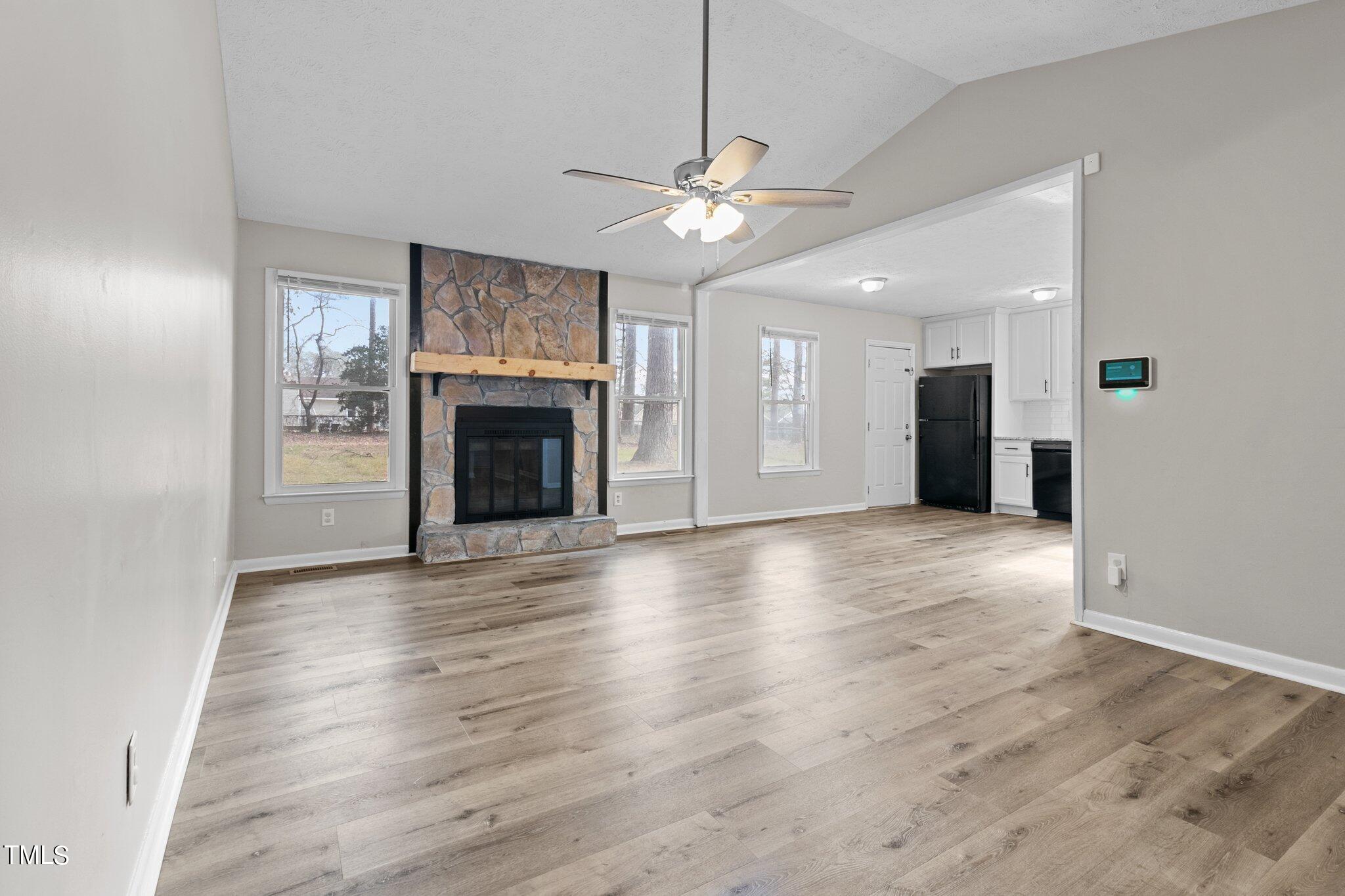 1775 Rim Road Fayetteville, NC 28314 - Photo 3 of 16 an empty room with wooden floor fireplace and fan
