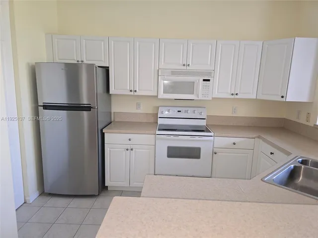 a kitchen with stainless steel appliances granite countertop a refrigerator and a stove top oven