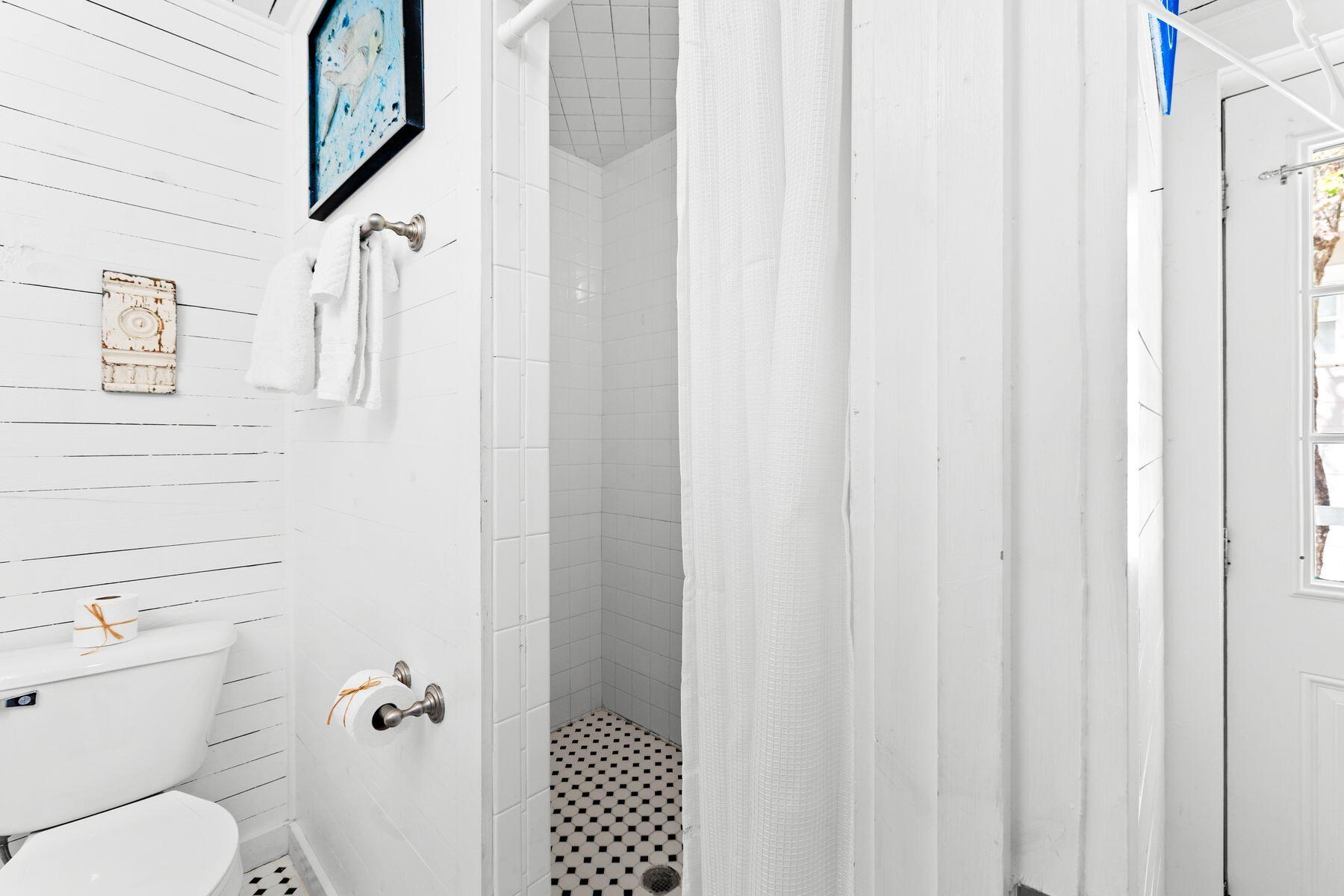 147 Magnolia Street Santa Rosa Beach, FL 32459 - Photo 21 of 33 a white toilet sitting next to a shower curtain