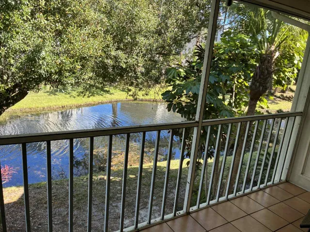 a living room with furniture a flat screen tv and a floor to ceiling window