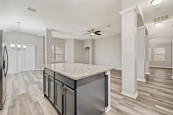 a kitchen with granite countertop kitchen island a sink stove and cabinets