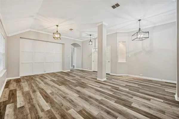 a view of a room with a dresser and chandelier fan