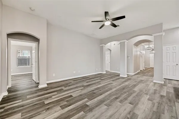 a view of a livingroom with wooden floor and a ceiling fan
