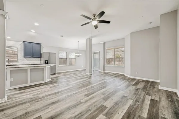 a view of a kitchen with wooden floor and a ceiling fan