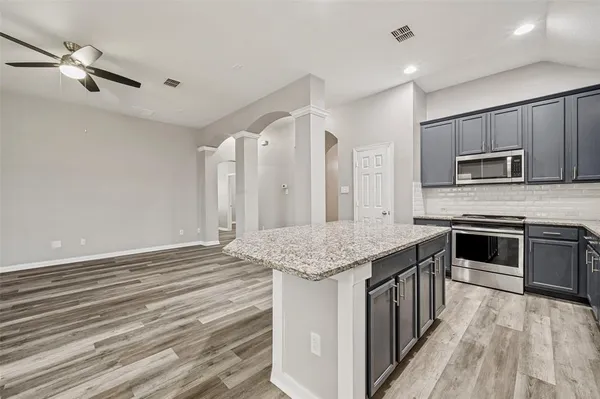 a kitchen with stainless steel appliances kitchen island granite countertop a stove and a sink