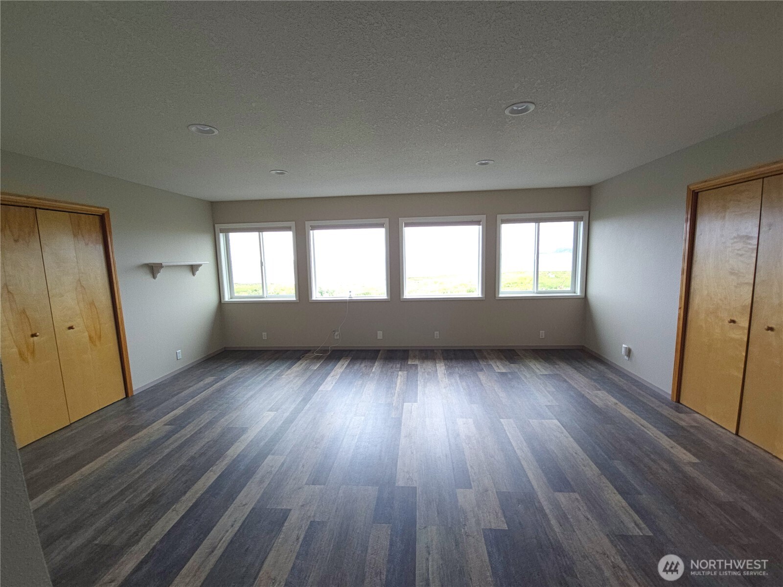 240 Stringtown Road Ilwaco, WA 98624 - Photo 12 of 39 an empty room with wooden floor and windows