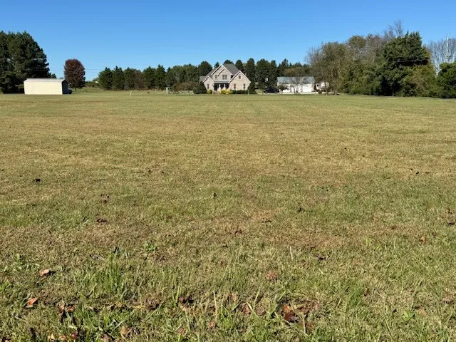 a front view of house with yard and trees in the background