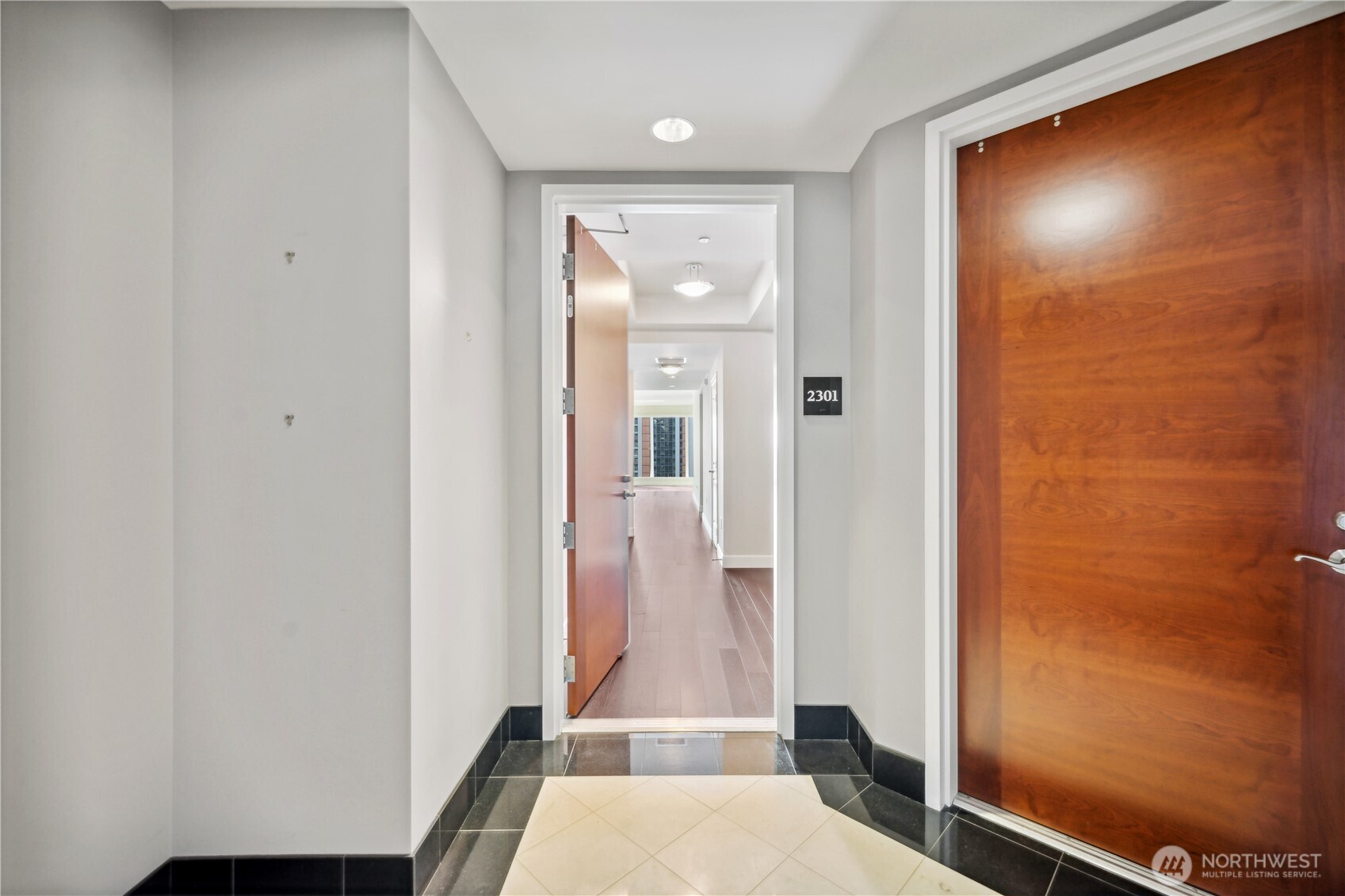 1920 4th Avenue, Unit 2301 Seattle, WA 98101 - Photo 2 of 40 a view of a hallway with wooden floor and a bathroom