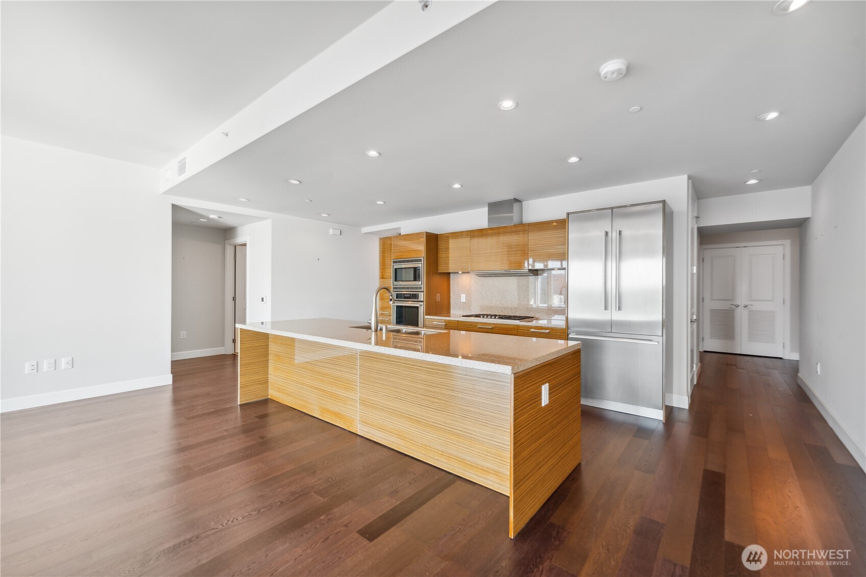 1920 4th Avenue, Unit 2301 Seattle, WA 98101 - Photo 8 of 40 a large kitchen with stainless steel appliances granite countertop a large counter top a sink and a refrigerator
