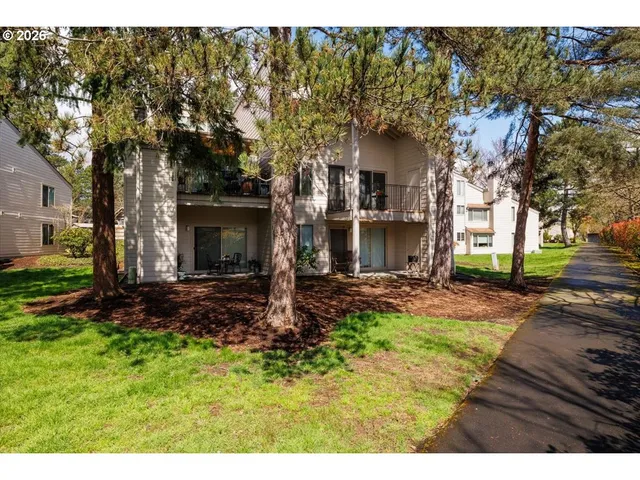 a view of a house with backyard and trees