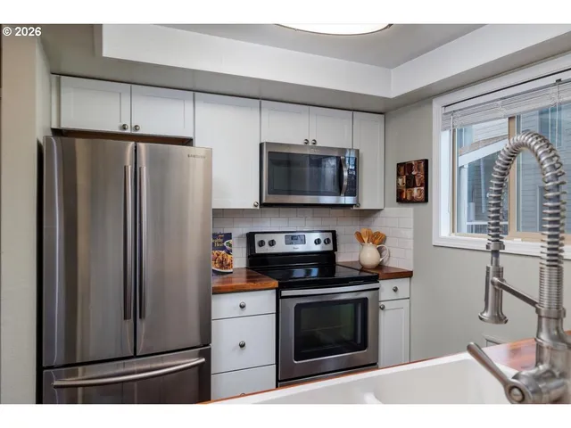 a kitchen with stainless steel appliances a stove microwave and refrigerator