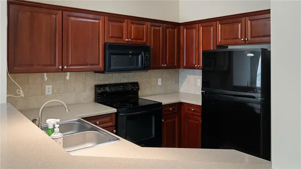 a kitchen with granite countertop a refrigerator stove and sink