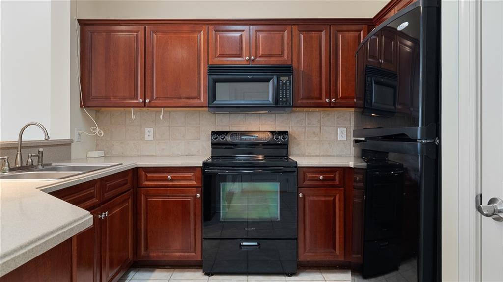 3309 Village Boulevard Southeast Rome, GA 30161 - Photo 9 of 38 a kitchen with stainless steel appliances granite countertop wooden cabinets and a stove top oven