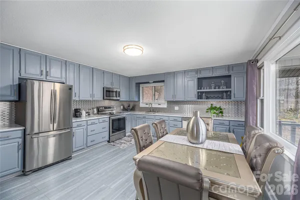a kitchen with white cabinets and stainless steel appliances