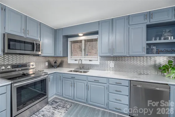 a kitchen with stainless steel appliances granite countertop a sink stove and microwave