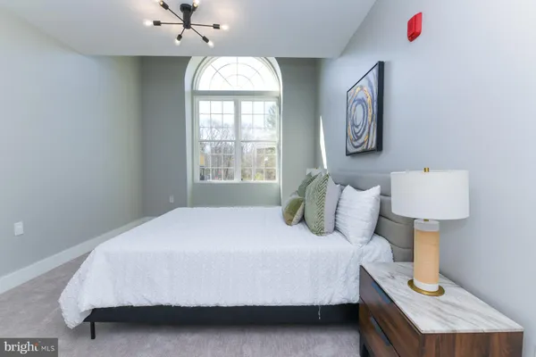 a bedroom with a bed and a chandelier