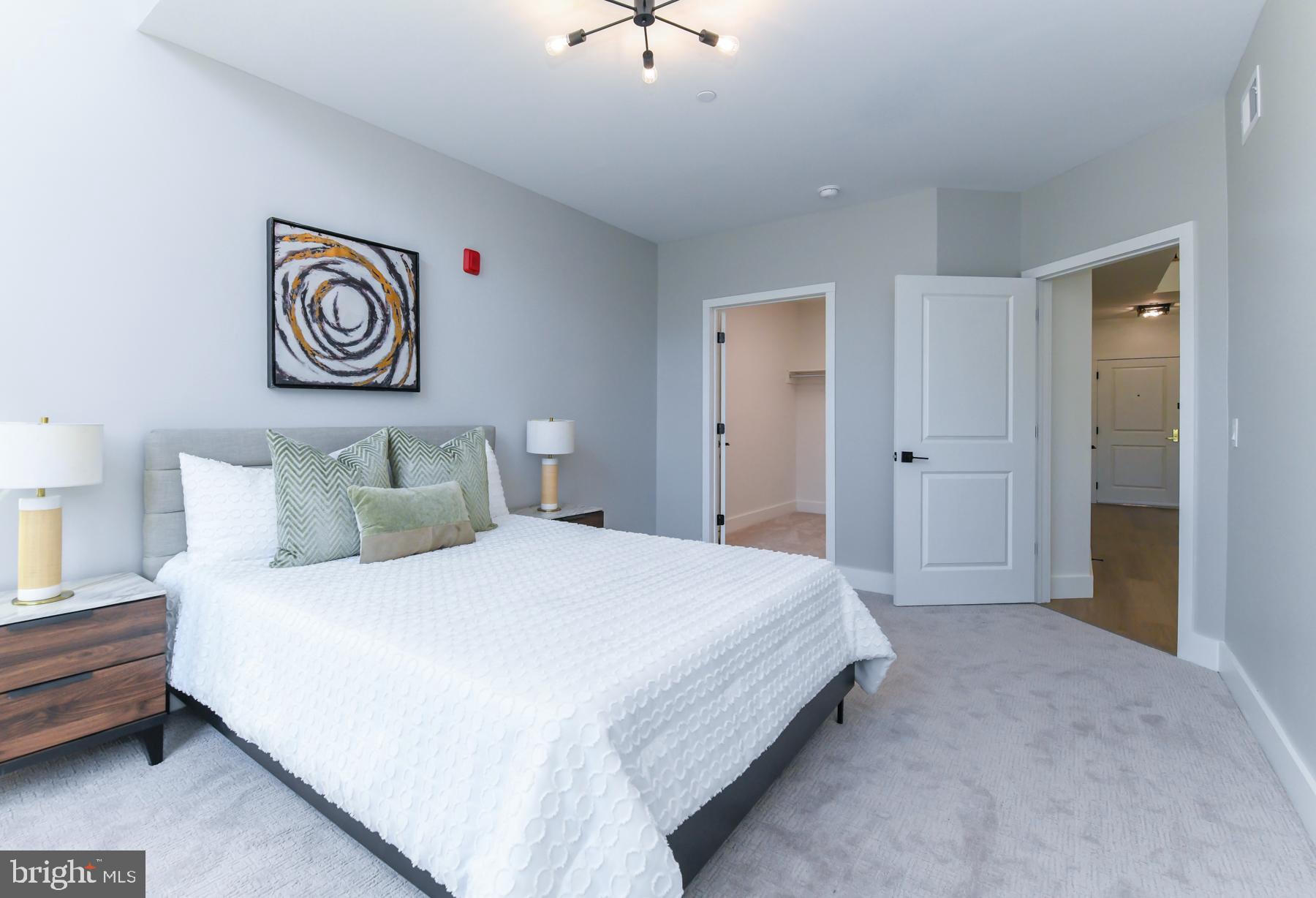 100 Aura Road, Unit 212 Clayton, NJ 08312 - Photo 12 of 19 a bedroom with a bed and a chandelier