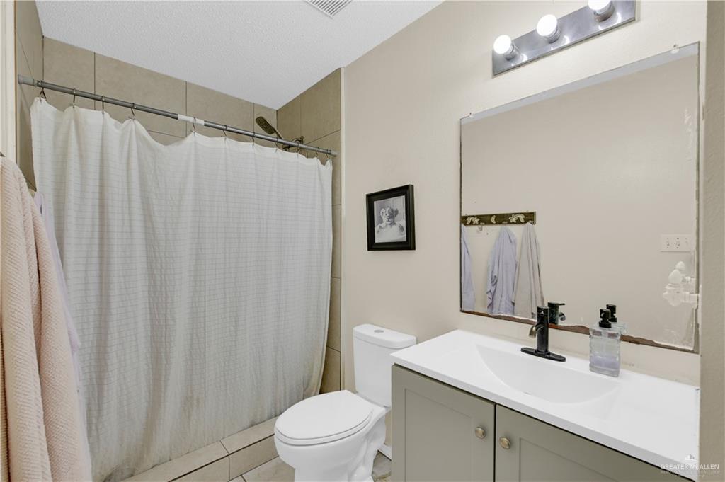 3301 Princeton Avenue McAllen, TX 78504 - Photo 17 of 21 a bathroom with a sink a toilet a mirror and shower curtain