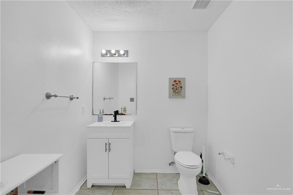 3301 Princeton Avenue McAllen, TX 78504 - Photo 5 of 21 a bathroom with a sink a toilet and a mirror