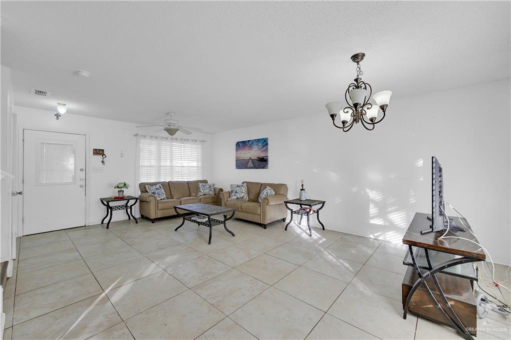 3301 Princeton Avenue McAllen, TX 78504 - Photo 7 of 21 a living room with furniture a dining table and a chandelier